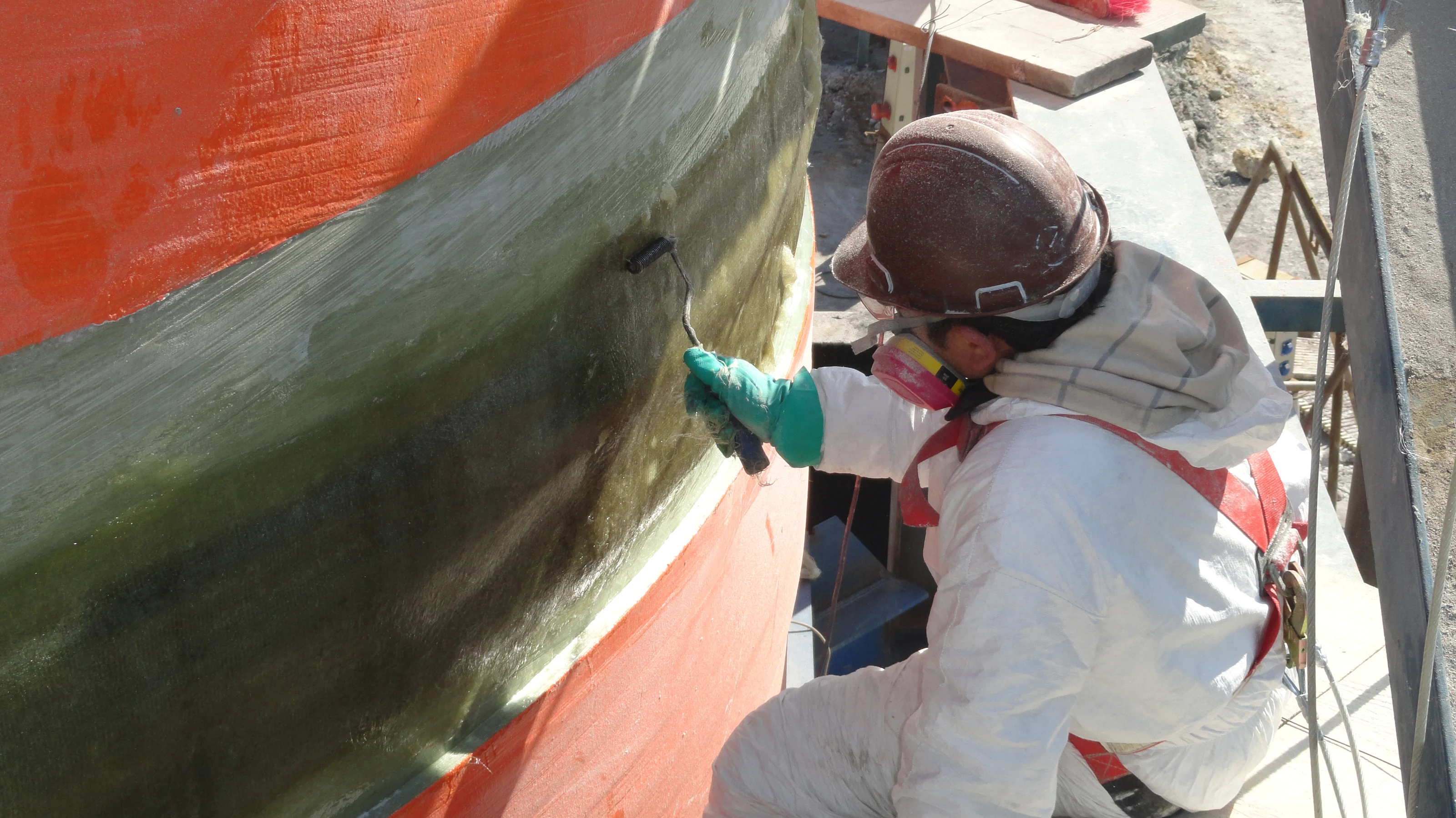 Worker hand-laminating the exterior shell of the FRP acid product tank.