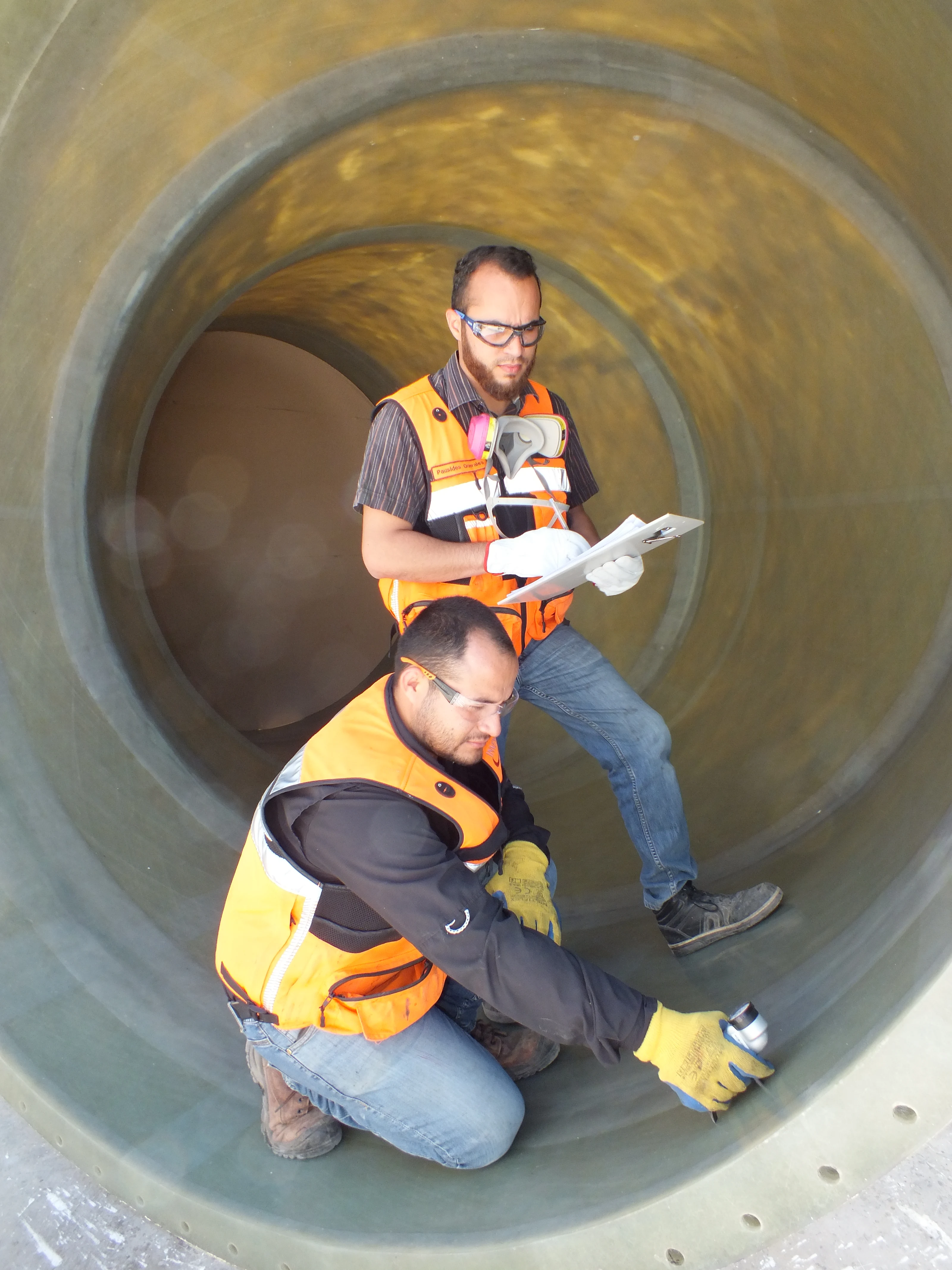 Workers inspecting the interior of FRP equipment.