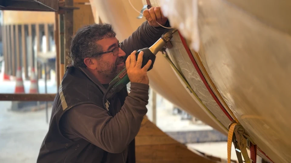 Worker applying hot-air welding to the inner liner of a large-diameter piece.