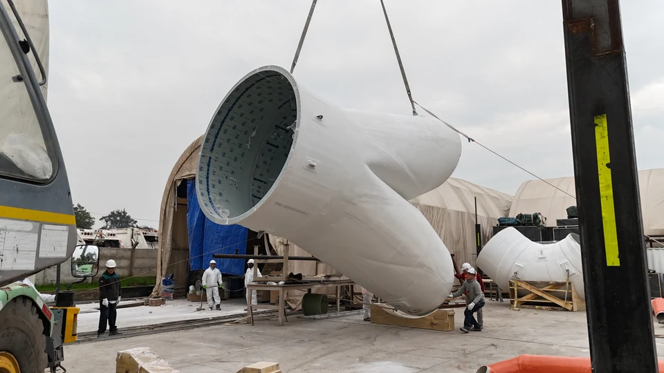 Pants duct section being lifted by crane during its fabrication.