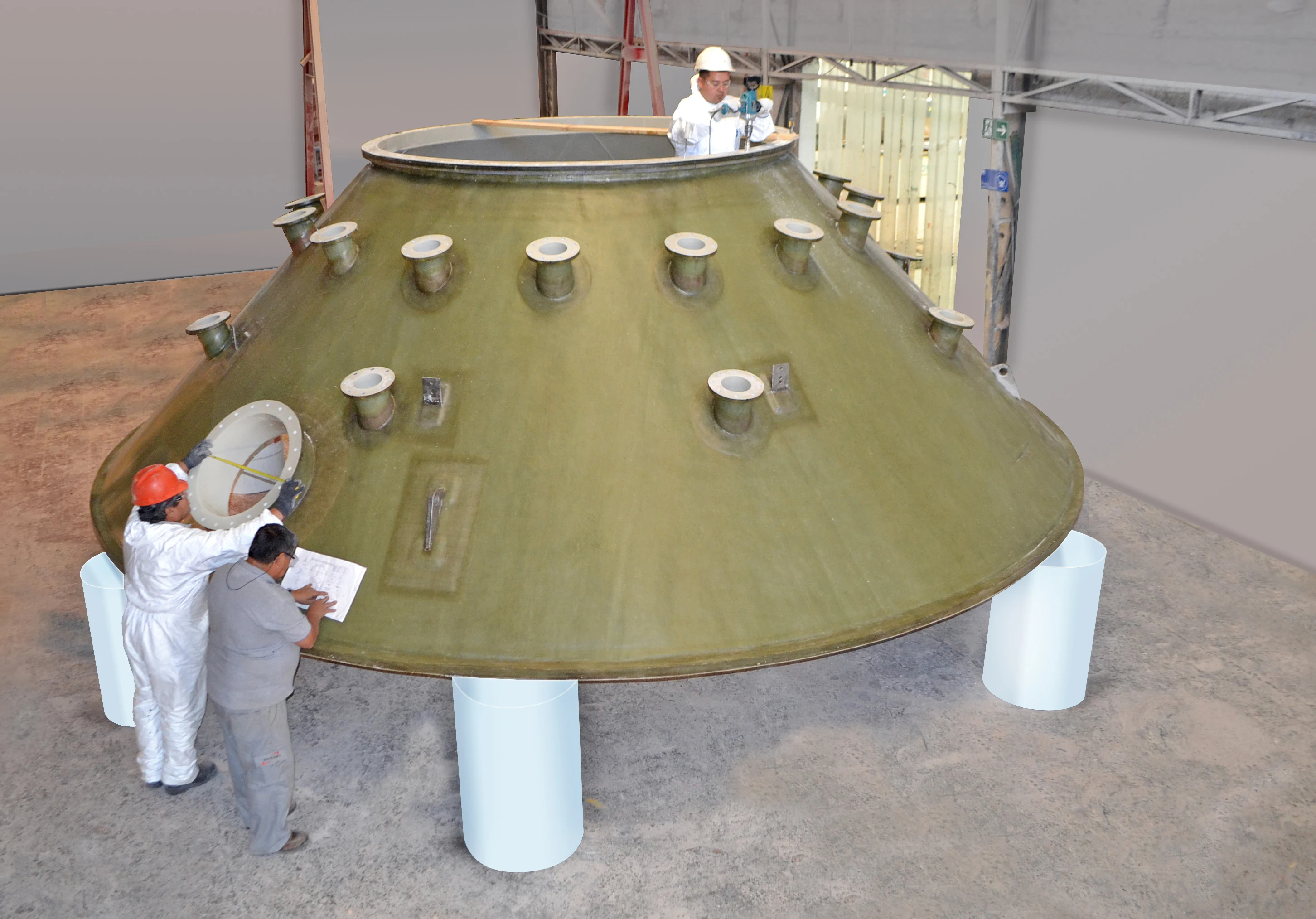 Trabajadores midiendo y verificando una boquilla embridada de un equipo industrial de gran formato fabricado en FRP.