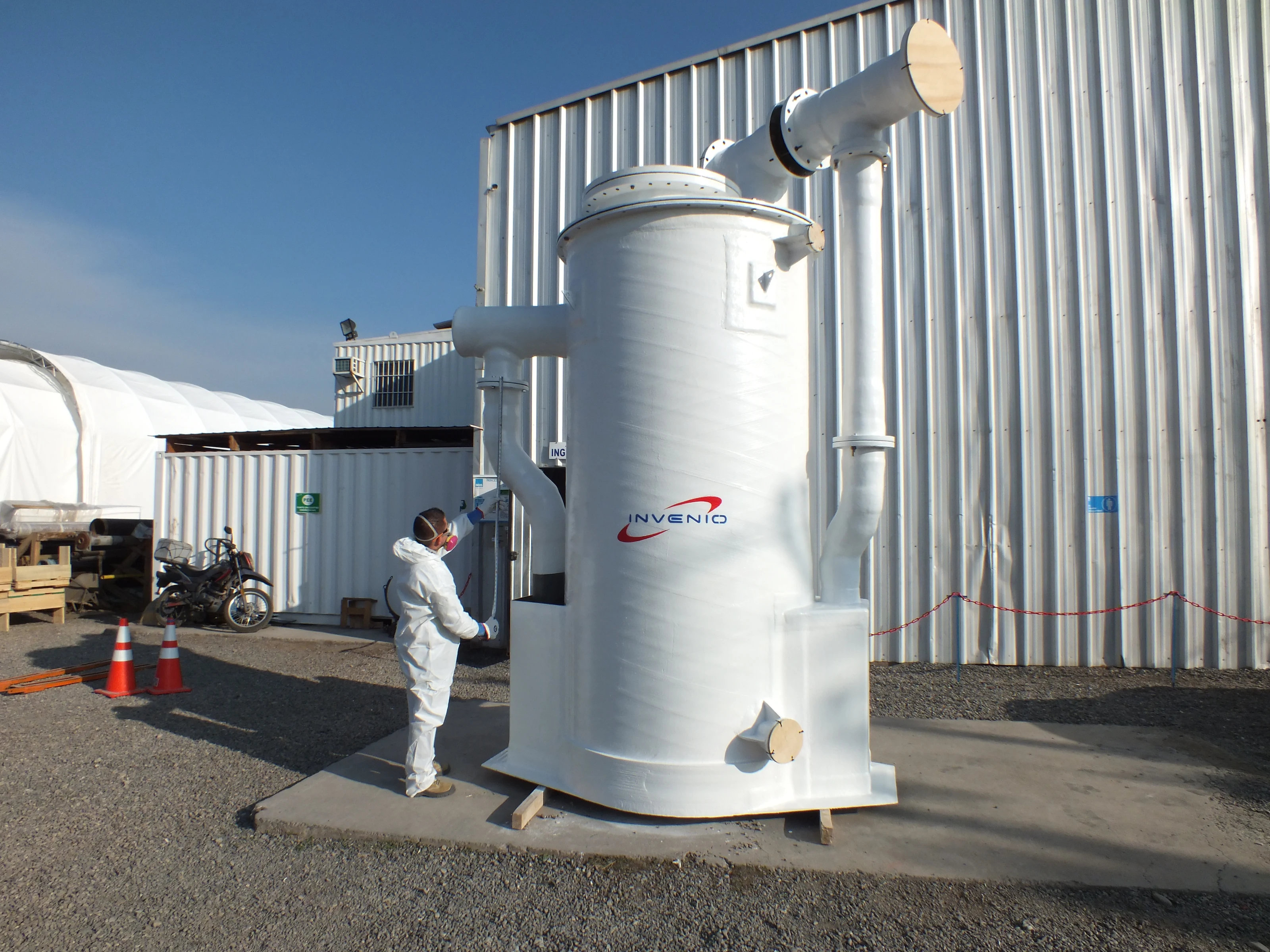 Worker next to FRP industrial equipment in the plant yard.
