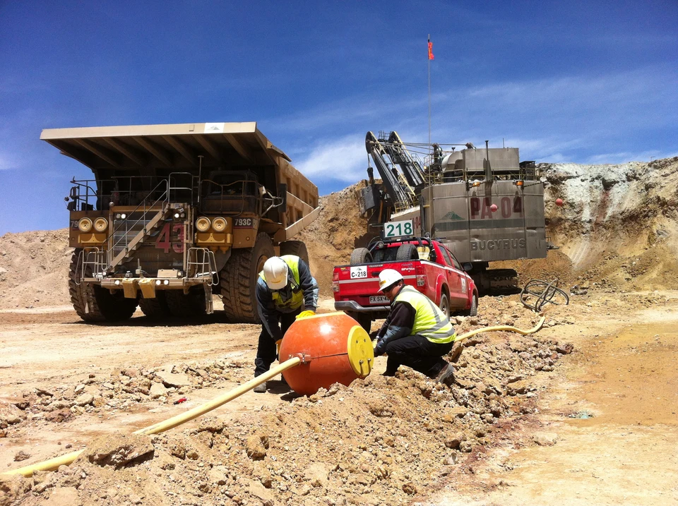 Workers performing field work at an industrial operation.
