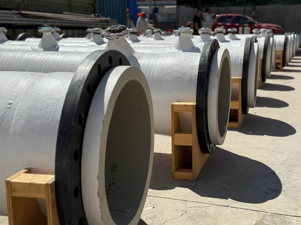 Row of flanged FRP spools resting on wooden blocks in the yard, ready for dispatch.